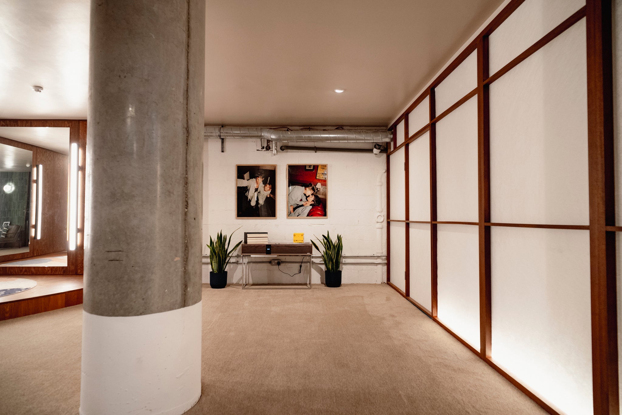 Modern interior design with concrete column, wall art, and plants.