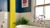 Bathroom with blue bathtub, electric yellow radiator, and white tiles.