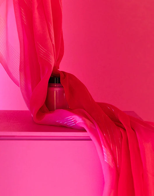 Pink fabric draped over a surface with a pink background