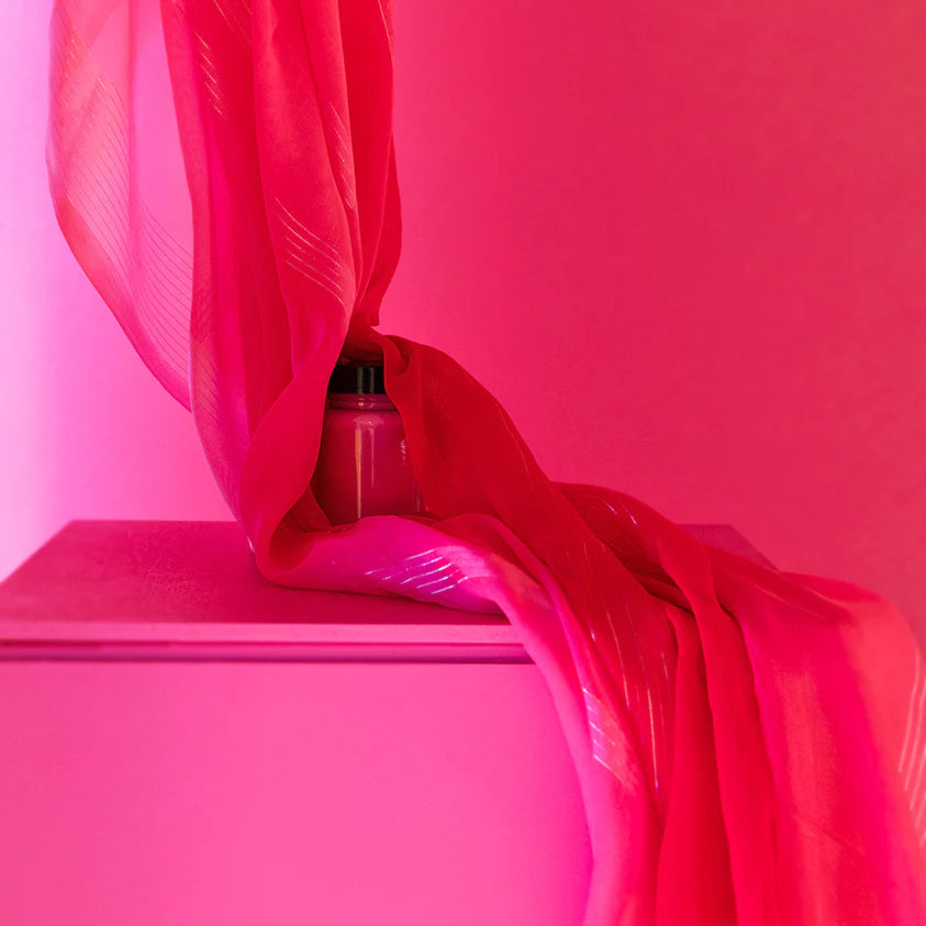 Pink fabric draped over a surface with a pink background